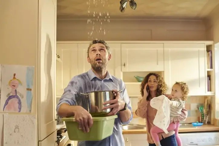 Melbourne family using a bucket to catch water from a ceiling leak