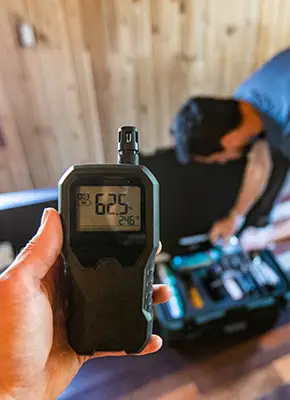 Specialist using monitoring equipment to check indoor air quality after fire damage