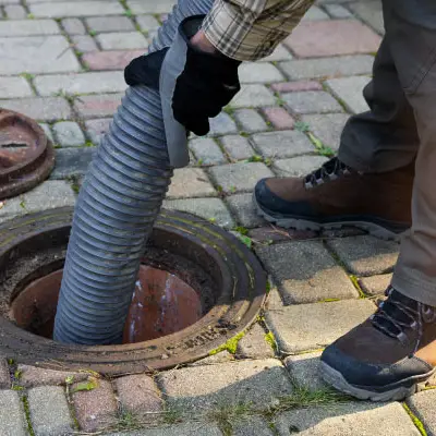 Technician cleaning a blocked sewage line in a residential Melbourne property