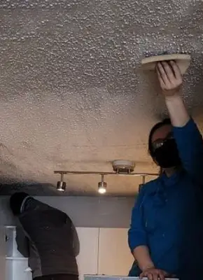 Restoration team cleaning blackened walls after heavy smoke damage