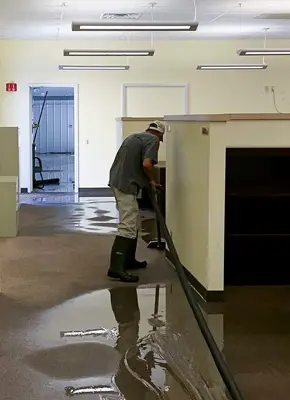 Technicians using industrial-grade equipment for flood water extraction at a damaged property