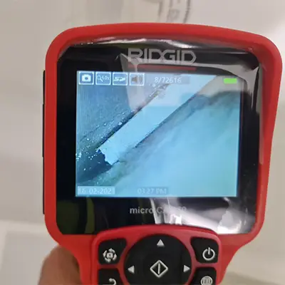Leak detection expert using a thermal camera to identify a hidden water leak in a Melbourne property