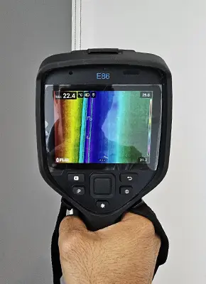 Leak detection technician using thermal imaging to scan for hidden water leaks in a Melbourne property