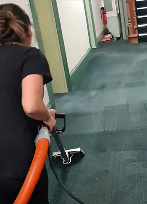 Technician extracting moisture from soaked carpet using industrial equipment in a Melbourne property