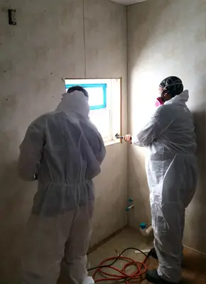 Technician sealing off a fire-damaged apartment to prevent further damage and contamination