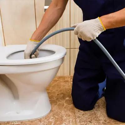 Technician cleaning a blocked and contaminated sewer drain in a Melbourne residential area