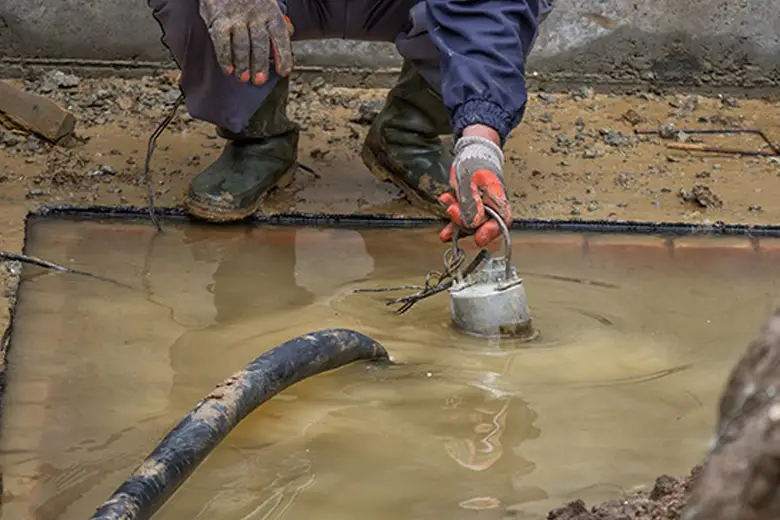 Technicians using high-powered pumps to extract standing water from a flooded property in Melbourne