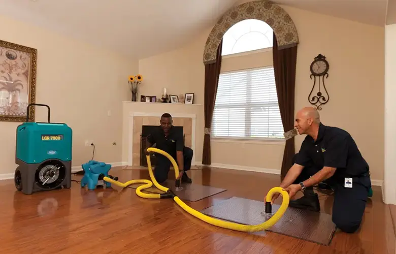 Restoration team drying a water-affected floor and sanitising the area in a Melbourne property