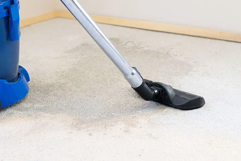 Technician using air movers and dehumidifiers to dry wet carpet in a Melbourne home