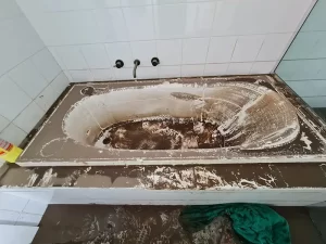 Bathtub filled with silt and debris after a flood in a Melbourne home, showing signs of severe water damage.