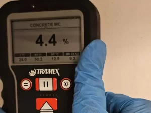 Moisture meter being used to assess moisture levels in a concrete wall during inspection in a Melbourne property.