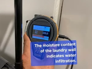 Moisture meter displaying high moisture content in a laundry wall, indicating water infiltration in a Melbourne property.