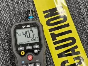 Moisture meter indicating elevated moisture levels in a carpet affected by water damage in a Melbourne property.