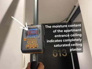 Moisture meter reading indicating that the ceiling of an apartment in Melbourne is damp and water affected.