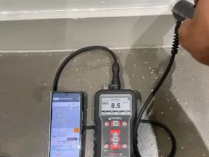 Real-time moisture mapping being conducted on building materials in a Melbourne property using advanced technology.