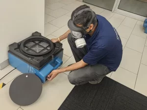 Technician setting up an air mover to aid structural drying in a water damaged Melbourne property.