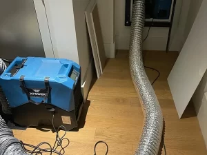 Water damage restoration in progress in a flooded basement using industrial drying and extraction equipment in Melbourne.