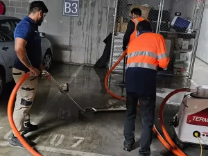 Water extraction process underway in a flooded basement of a Melbourne property using industrial equipment.