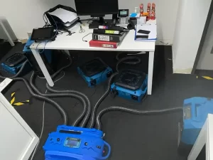 Professional drying equipment set up to dry wet carpet and structural elements in a flooded office space in Melbourne.